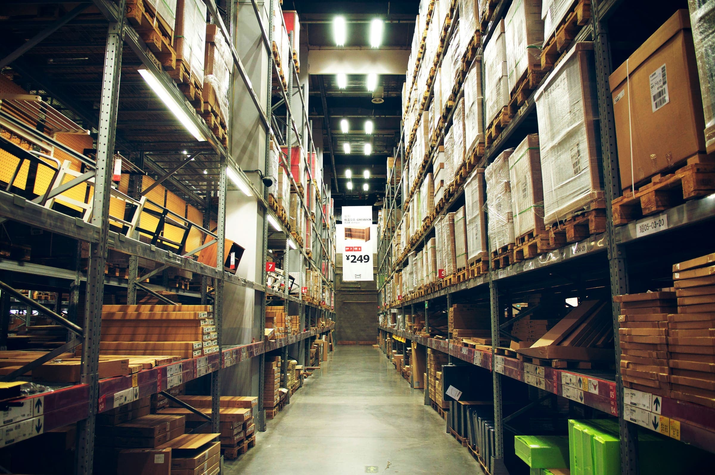 Long stockroom shelves stacked with boxed stock